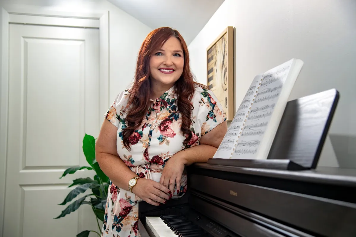 Jodi Cassaniti standing at the piano in her studio